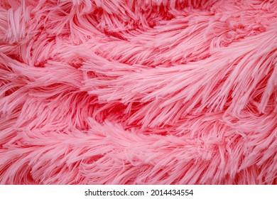 Pink Fluffy Fur, Fashion Background. Fashionable Rose Color Fur Texture. Long Hair Pink Furry Carpet Texture. Decorative Pink Dyed Sheepskin Long Hair Rug.