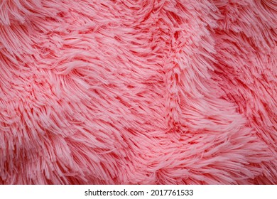 Pink Fluffy Fur, Fashion Background. Fashionable Rose Color Fur Texture. Decorative Pink Dyed Sheepskin Long Hair Rug. Long Hair Pink Furry Carpet Texture.