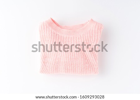 Pink folded sweater isolated on white background. Flat lay. Top view
