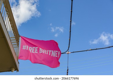 Pink "Free Britney" flag flapping in the breeze on a building in Uptown New Orleans, LA, USA
