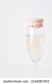 Pink French Macaron Sitting On Top Of A Champagne Flute Filled With Prosecco Bubbly 