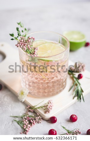 pink fresh cocktail with berry and cut lime on stone desk background