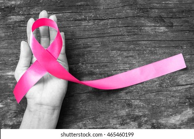 Pink fuchsia ribbon on woman's hand (isolated with clipping path) for raising Breast cancer awareness and women's health campaign - Shutterstock ID 465460199
