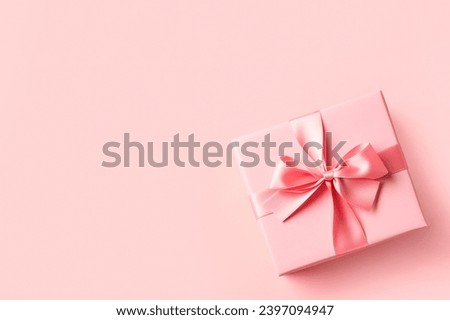 Pink gift box on a pink background. Top view, space for text.