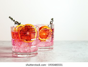 Pink gin cocktail with red blood orange and ice. An alcoholic, refreshing drink. copy space.