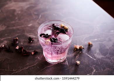 Pink Gin And Tonic Cocktail With Hibiscus And Dried Rose Buds