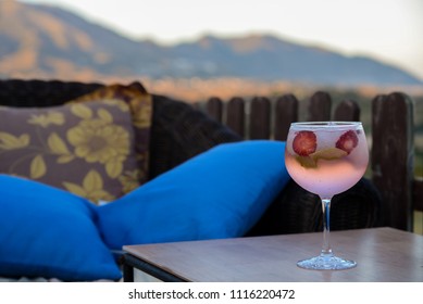  Pink Gin And Tonic With Strawberry In The Glass With Spanish Countryside Background.