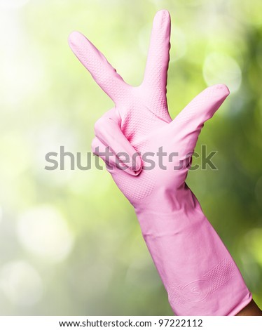 pink gloves of maid gesturing number three against a nature background