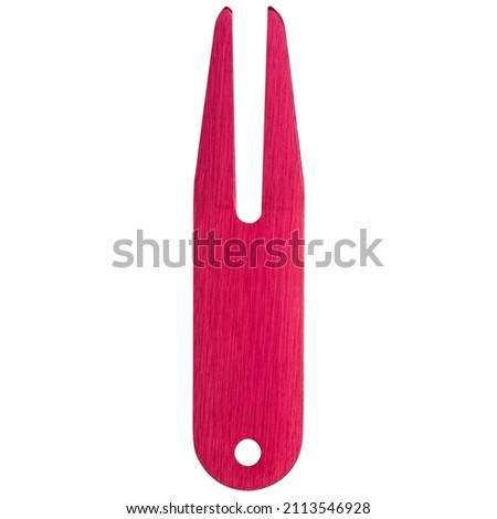 Pink golf divot tool or divot replacer on white background. Closeup.