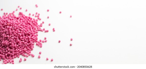 Pink granules of polypropylene or polyamide on a white background. Plastics and polymers industry. Copy space.	Banner