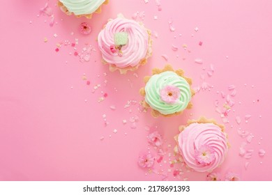 Pink And Green Cupcakes With Spring Flowers  On Pink  Background