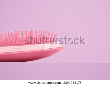 Pink hair comb, styling. Haircare acessories. Copy space for text.