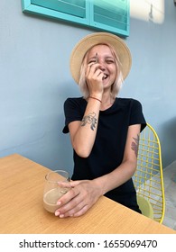 Pink Hair Girl In A Hat Laughing Smoking Joint And Have Coffee Outside.