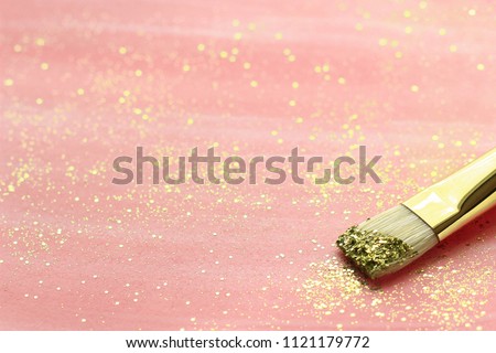 Pink hand-painted paper with brush and   gold glitter. Selective focus.