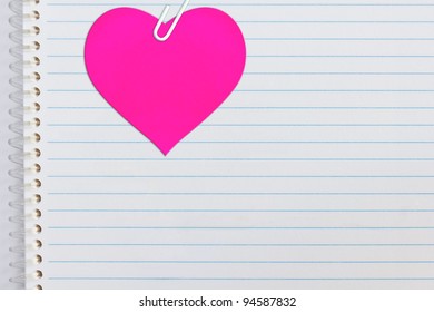 Pink Heart Attached On Notebook Paper With Paperclip