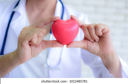 Pink Heart in the hands of the doctor who mediates health. Pink heart that expresses love and concern. Women holding the pink heart. Valentine’s Day. Love concept. Health concept. selective focus.