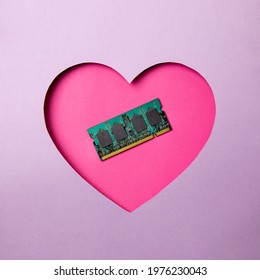 Pink heart shape on a purple background. At the heart are a memory frame for a computer and laptop. Minimal concept love computers.