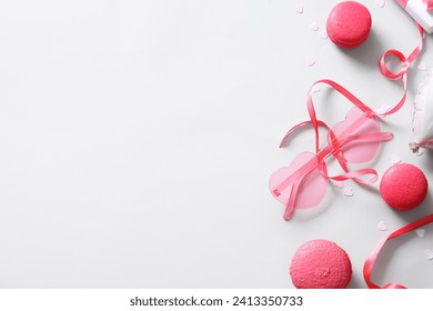 Pink heart shaped sunglasses with macarons and decor on white background. Valentine's Day concept