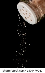 Pink Himalayan Salt Falling Out From A Salt Shaker On A Black Isolated Background