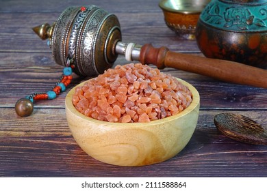 Pink Himalayan Salt In Wooden Bowl With Tibetan Buddhism Prayer Wheel. Selective Focus With Copy Space