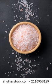 Pink Himalayan Salt In A Wooden Bowl With Scattered Salt Isolated On A Black Background, Top View, Flat Lay