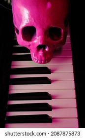 Pink human skull on electric piano keyboard for scary musical performance