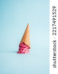 Pink Ice Cream cone upside down, minimal blue background