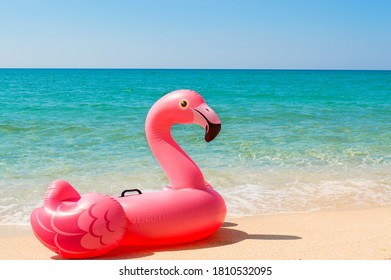 Pink inflatable mattress Flamingo on the beach close-up. The concept of tourism, travel, vacations