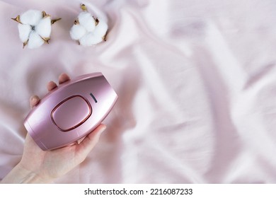 Pink IPL hair removal handset on a satin background - Shutterstock ID 2216087233
