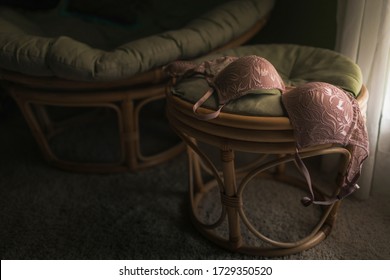 Pink lace bra in shadows of a seventies style room with window light