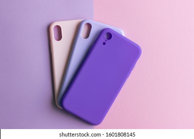 Pink, lilac and purple cases for the smartphone on the grey background. Protective silicone cases for smartphone. Colorful silicone cases for your smartphone.