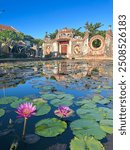 Pink lily pads in front of beautiful temple in Hoi An, Vietnam