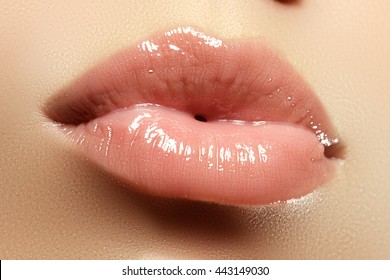 Pink lip gloss and lipstick. Close-up of a beautiful sexy natural lips giving kiss. Nice full lips with gloss lip makeup. Fashion makeup. Sexy lips. Beauty lips makeup detail