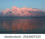 Pink lit cumulus cloud over Lake Vanern, Sweden.