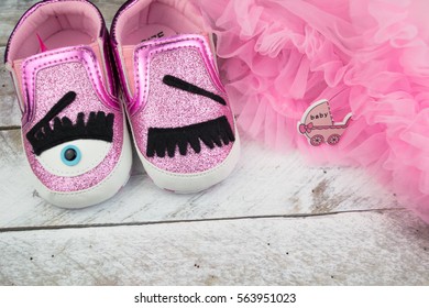 Pink Little Girlie Baby Shoes On A Wooden Floor