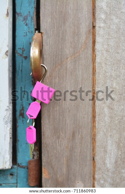 Pink lock and key hook on\
the door.