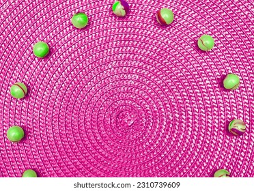 Pink magenta spiral round straw background with green balls. Place for text                                - Shutterstock ID 2310739609