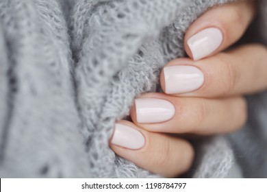 Pink manicure nails with a grey scarf