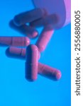 Pink Medication Capsules on Blue Background