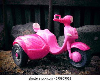 A pink motorcycle. A toy.