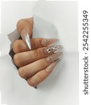 Pink nails with elegant accessories, featuring delicate embellishments like gold studs or shimmering gems. This stylish design adds a touch of sophistication, perfect for any occasion or a chic 