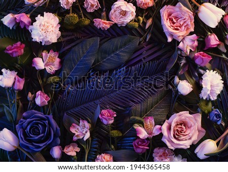 Pink neon lights  colorful flowers arrangement  with natural green  leaves. Minimal flower concept. Flat lay. Abstract floral composition.