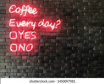 A Pink Neon Sign With Yes Or No Question On Black Brick Wall At Coffee Shop.