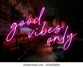 A pink neon style Good Vibes Only sign in front of a bar or pub. Slightly blurred bar or tavern background. Nightlife concept. - Powered by Shutterstock