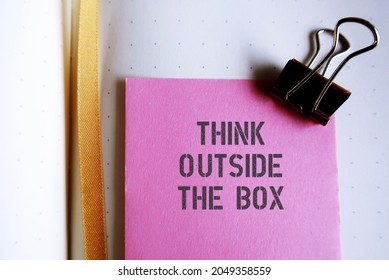 Pink Note On Notebook With Text Written THINK OUTSIDE THE BOX , Concept Of Breaking Status Quo To Find Innovative Solution Or Create Something Differently, Stand Out From The Crowd.