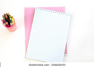 Pink notebook, opened notepad and pencils on a white background. Back to school, education concept, fashion office