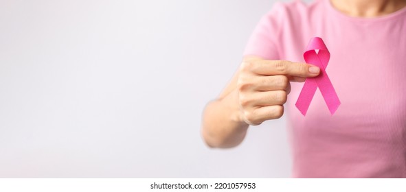 Pink October Breast Cancer Awareness month, woman hand hold pink Ribbon and wear shirt for support people life and illness. National cancer survivors month, Mother and World cancer day concept - Shutterstock ID 2201057953