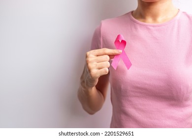 Pink October Breast Cancer Awareness month, woman hand hold pink Ribbon and wear shirt for support people life and illness. National cancer survivors month, Mother and World cancer day concept - Shutterstock ID 2201529651