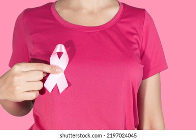 Pink October. Woman Holding Pink Ribbon On Pink Background.