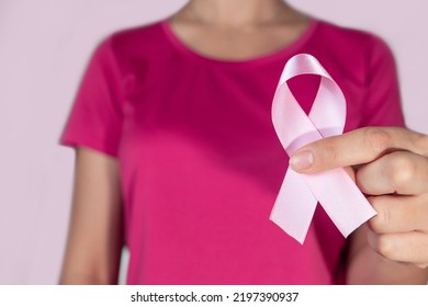 Pink October. Woman Holding Pink Ribbon On Pink Background.